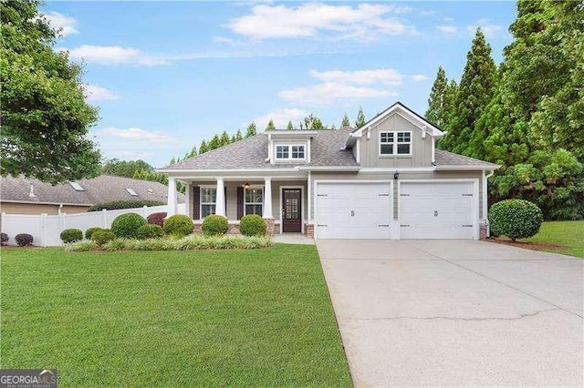 view of front facade featuring a porch, concrete driveway, fence, and a front lawn