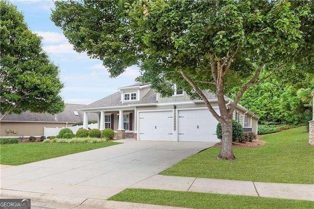 view of front of home featuring a garage, concrete driveway, and a front lawn