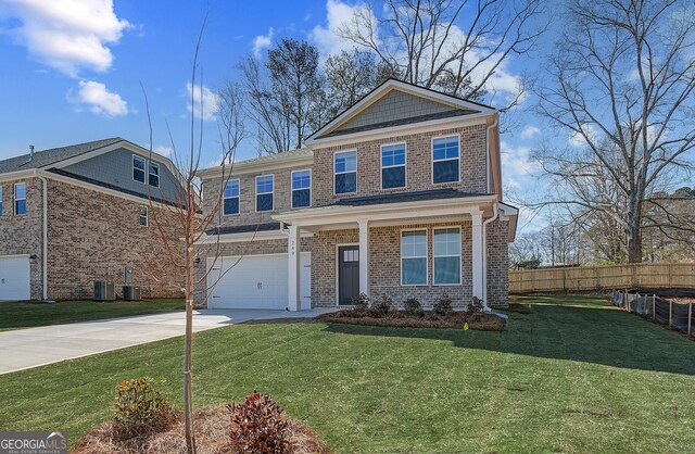 view of front of property featuring an attached garage, fence, driveway, stone siding, and a front yard