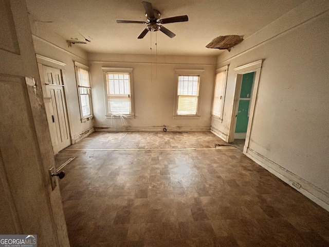 unfurnished room featuring ceiling fan and baseboards