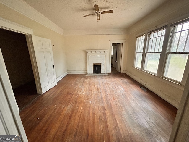 unfurnished living room featuring a healthy amount of sunlight, a fireplace, visible vents, and wood finished floors