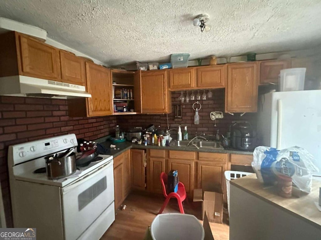 kitchen with open shelves, electric range, brown cabinetry, a sink, and under cabinet range hood