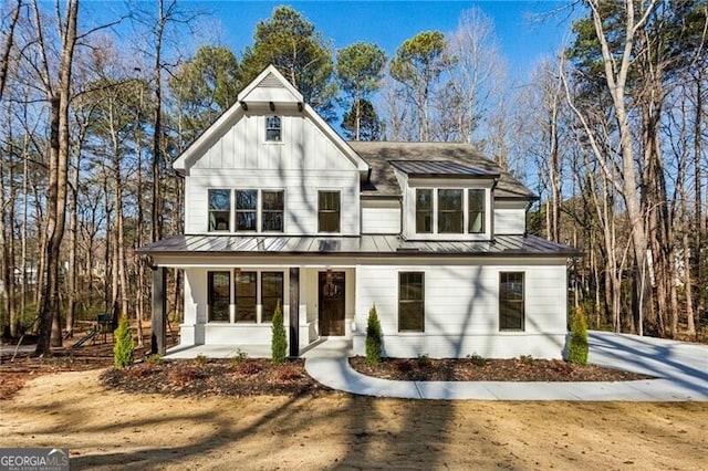 modern farmhouse featuring board and batten siding, a standing seam roof, a porch, and metal roof