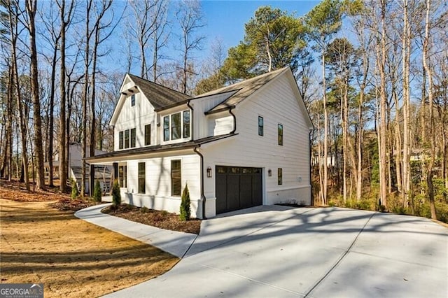 view of front of house with a garage, concrete driveway, and board and batten siding