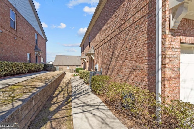 view of home's exterior with a garage and brick siding