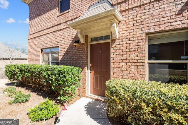 doorway to property with brick siding