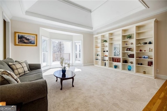 sitting room with baseboards, a tray ceiling, carpet, and crown molding