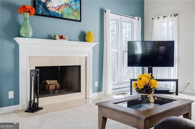 living area featuring carpet flooring, baseboards, and a premium fireplace