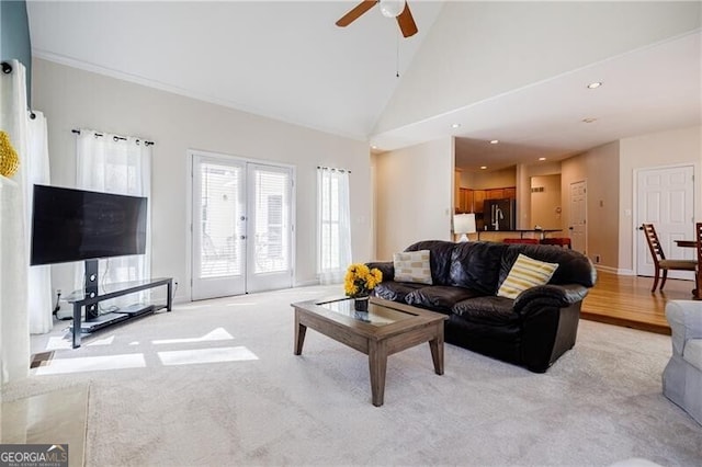 living room with light carpet, high vaulted ceiling, a ceiling fan, and french doors