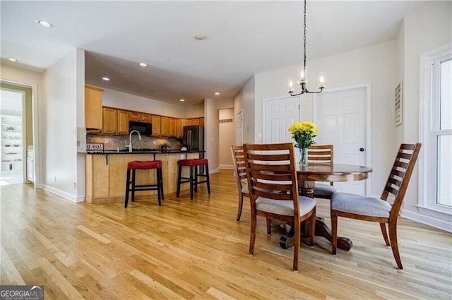 dining room with recessed lighting, a notable chandelier, light wood-style flooring, and baseboards