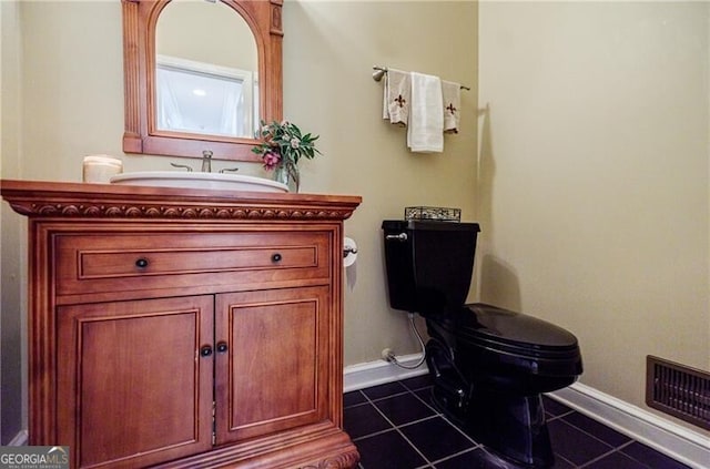 half bathroom with tile patterned flooring, visible vents, vanity, and toilet