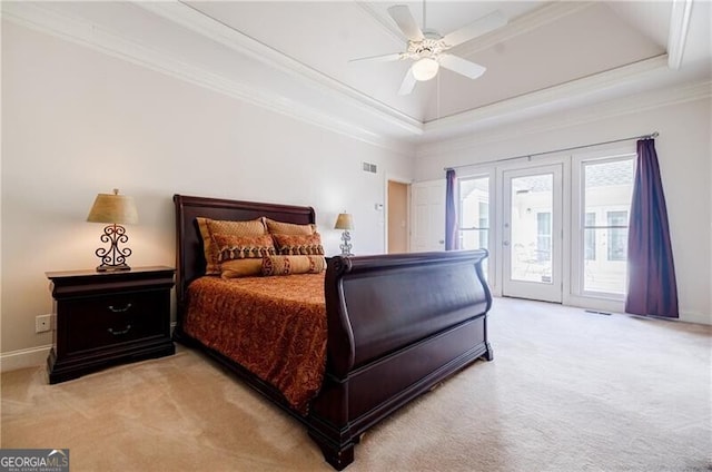 bedroom featuring access to exterior, a tray ceiling, visible vents, and light colored carpet