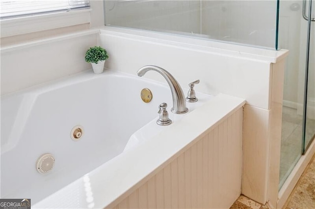 interior details featuring a jetted tub and a stall shower