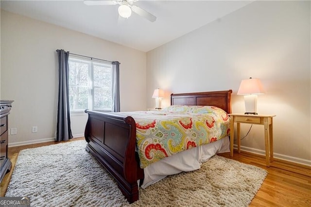 bedroom with lofted ceiling, a ceiling fan, baseboards, and wood finished floors