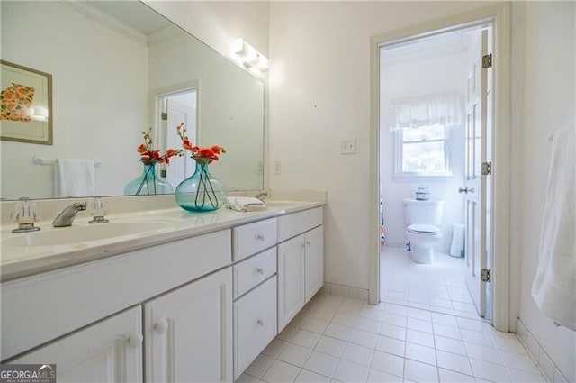 full bath featuring crown molding, double vanity, toilet, a sink, and tile patterned flooring