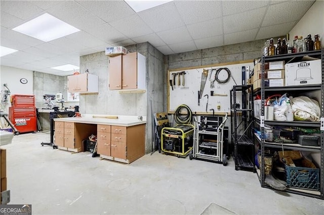 kitchen with a paneled ceiling, light countertops, and concrete floors