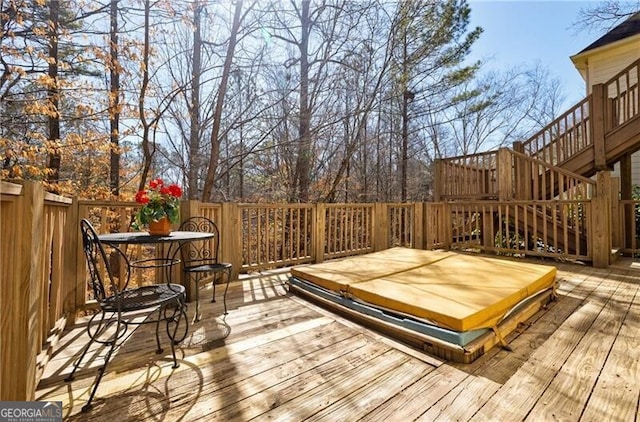 deck featuring a covered hot tub