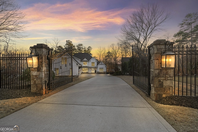 gate at dusk featuring fence