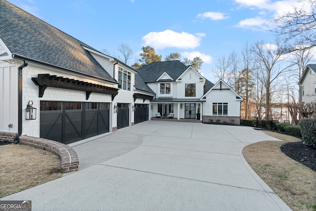 modern inspired farmhouse with a garage, a shingled roof, and concrete driveway