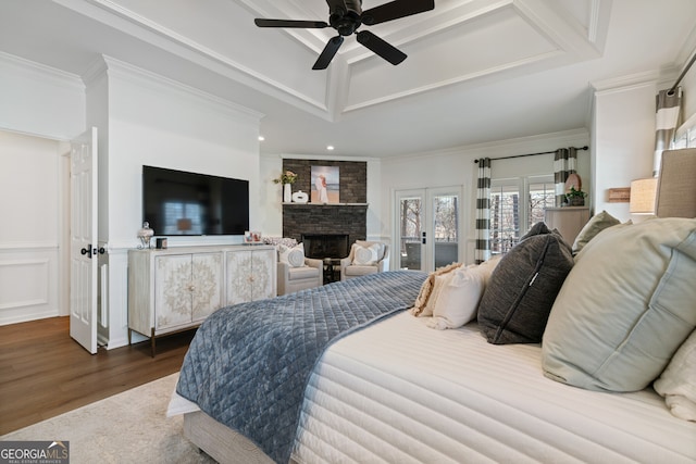 bedroom featuring access to outside, ornamental molding, a tray ceiling, and wood finished floors