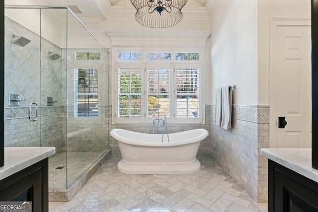 full bathroom with ornamental molding, a stall shower, a freestanding bath, and vanity