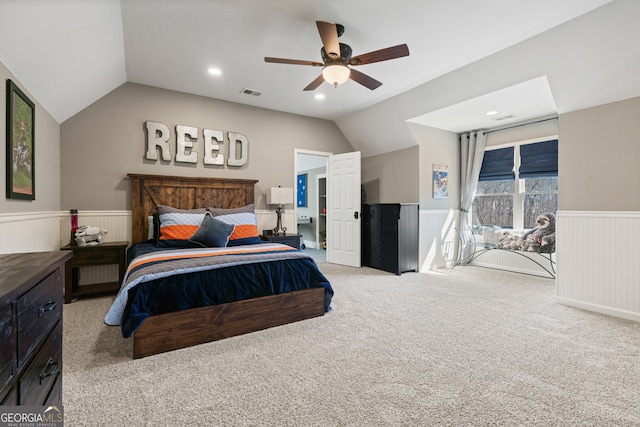 bedroom featuring carpet floors, a wainscoted wall, visible vents, and vaulted ceiling