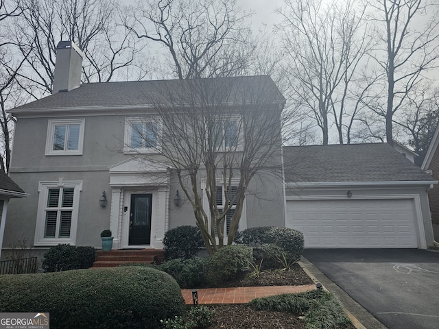 view of front of house with driveway, roof with shingles, an attached garage, and stucco siding