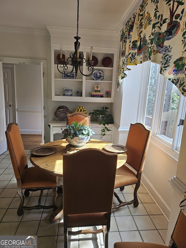 dining room with built in shelves, a notable chandelier, light tile patterned floors, ornamental molding, and baseboards