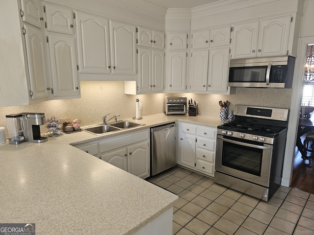 kitchen featuring light countertops, appliances with stainless steel finishes, a sink, and white cabinets