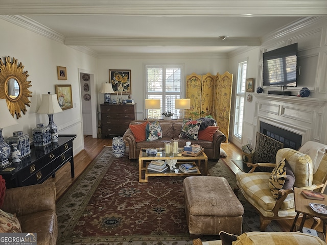 living room with ornamental molding, a fireplace, and wood finished floors