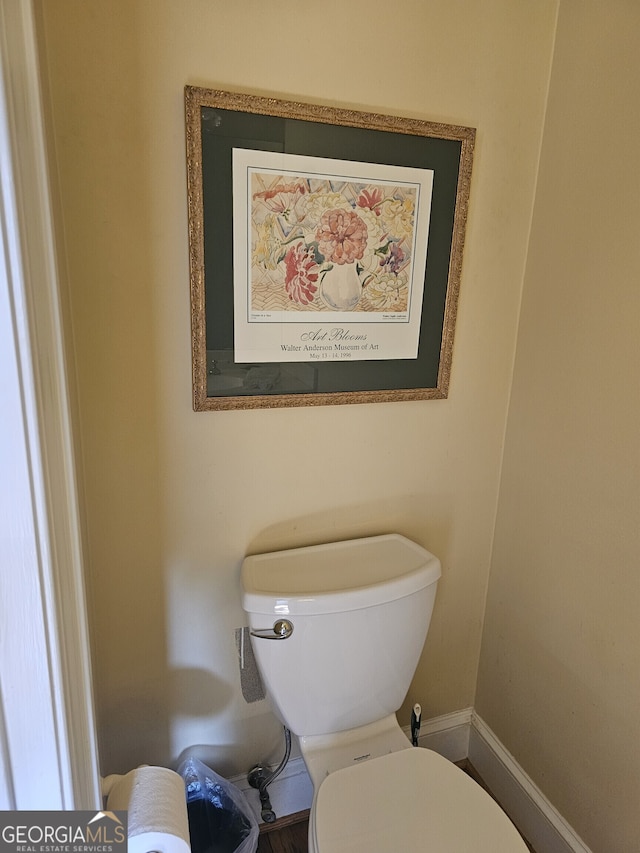 bathroom featuring toilet and baseboards