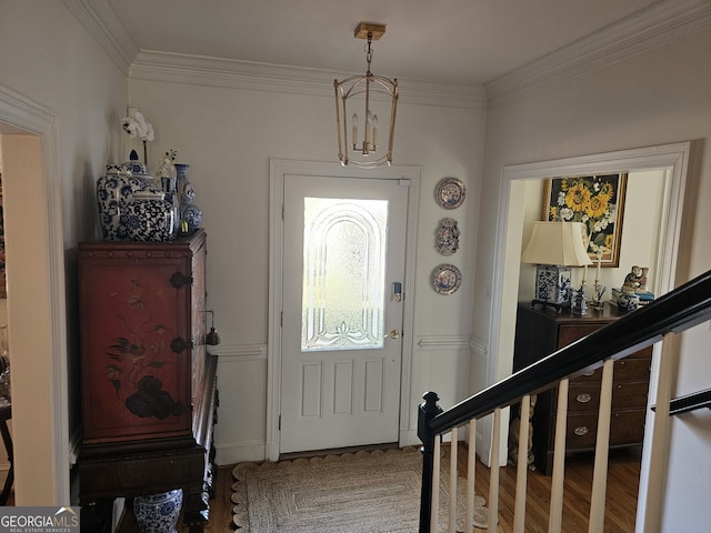 entrance foyer with stairs, crown molding, and wood finished floors