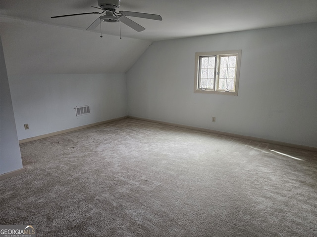 bonus room featuring baseboards, visible vents, a ceiling fan, lofted ceiling, and carpet