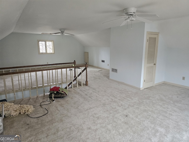 additional living space featuring light carpet, vaulted ceiling, visible vents, and baseboards