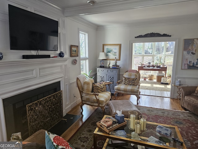 living area featuring crown molding, a wealth of natural light, and a fireplace