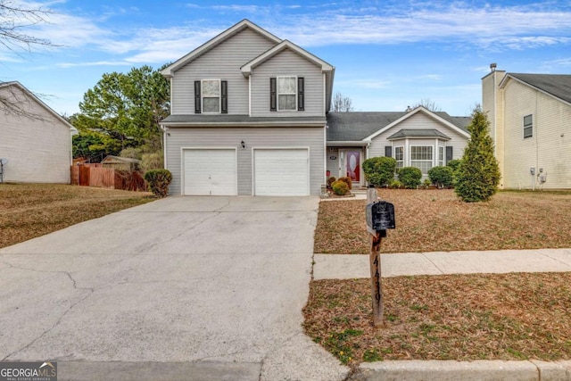 traditional home featuring a garage, fence, a front lawn, and concrete driveway