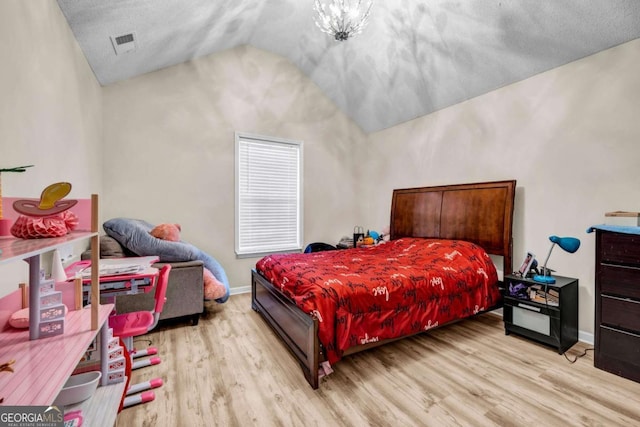 bedroom with lofted ceiling, baseboards, visible vents, and light wood-style floors