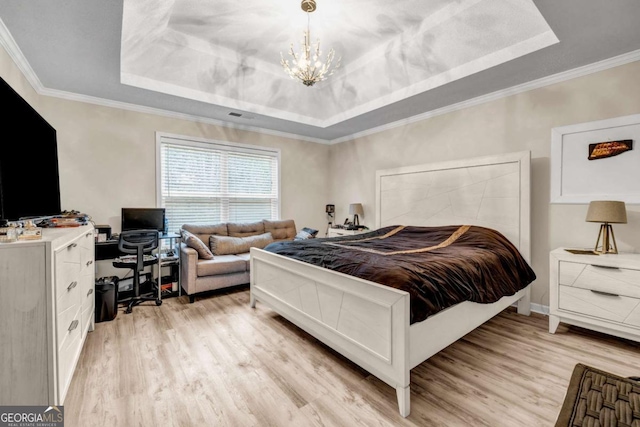 bedroom with crown molding, a tray ceiling, a notable chandelier, and light wood-style flooring