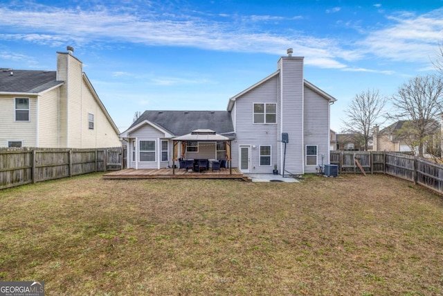 back of house with a lawn, a fenced backyard, a deck, a gazebo, and central AC