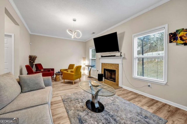 living room with baseboards, light wood-type flooring, and crown molding