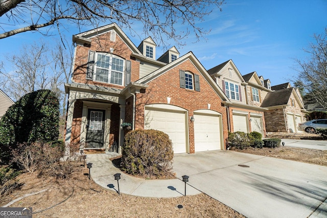 view of front of house featuring a garage, concrete driveway, and brick siding