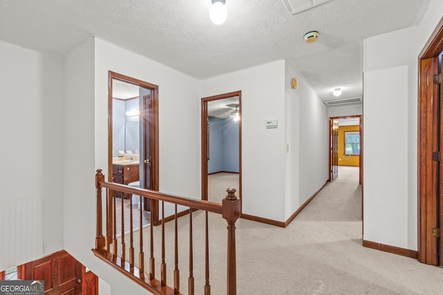 hall with baseboards, light carpet, a textured ceiling, and radiator heating unit