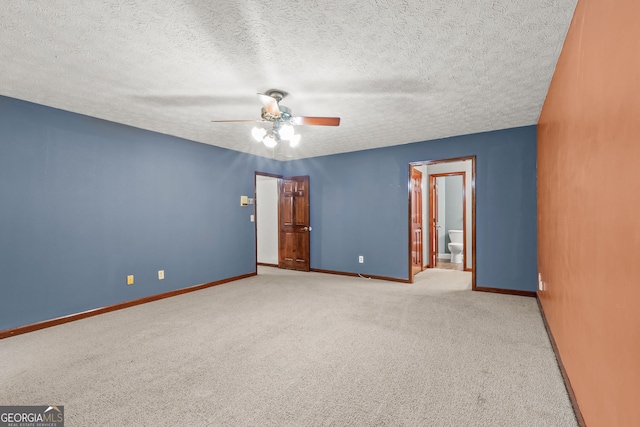 carpeted empty room with baseboards, a textured ceiling, and a ceiling fan
