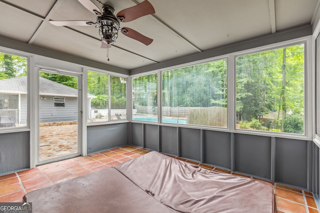 unfurnished sunroom featuring ceiling fan and plenty of natural light