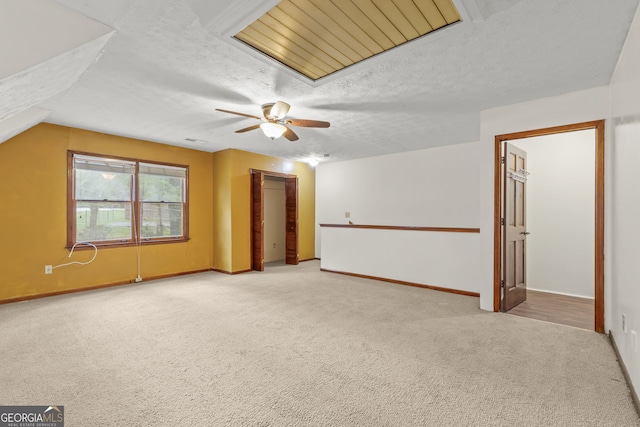 interior space featuring baseboards, carpet flooring, a textured ceiling, and a ceiling fan