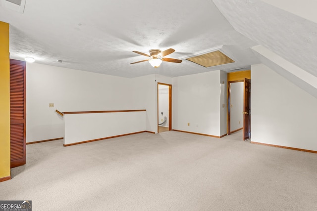 bonus room featuring light colored carpet, ceiling fan, a textured ceiling, and baseboards