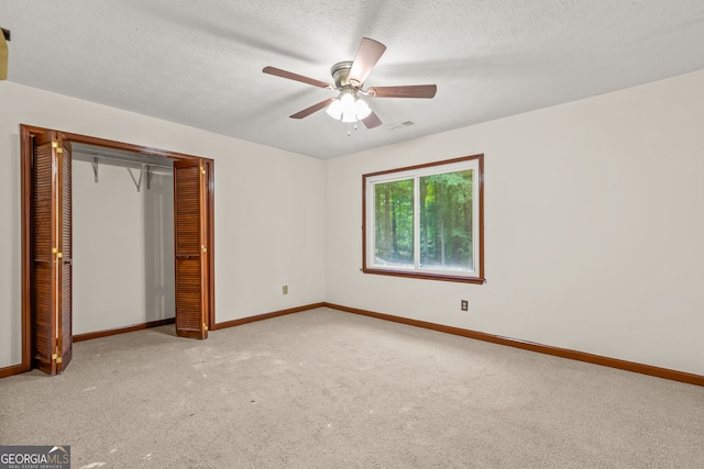 unfurnished bedroom featuring baseboards, visible vents, carpet floors, and a textured ceiling