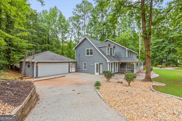 view of front of house featuring a garage, a shingled roof, and a porch