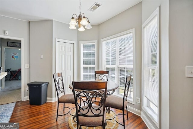 dining room featuring a chandelier, dark wood-style flooring, visible vents, and baseboards