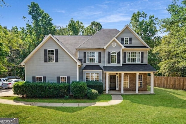 view of front of house with fence and a front lawn